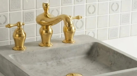 unlacquered brass widespread bathroom faucet installed on marble vanity sink