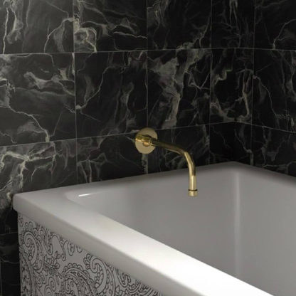 8-inch unlacquered brass wall-mount tub spout installed above a white bathtub with black marble wall