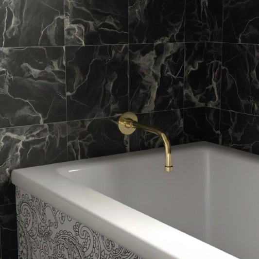 8-inch unlacquered brass wall-mount tub spout installed above a white bathtub with black marble wall