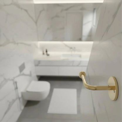 Top view of modern marble bathroom with wall-mounted unlacquered brass toilet paper holder, solid brass bathroom hardware with natural patina finish