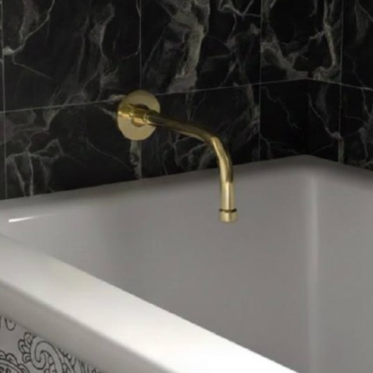 Unlacquered brass wall-mounted tub spout with curved design above a white bathtub against black marble tiles