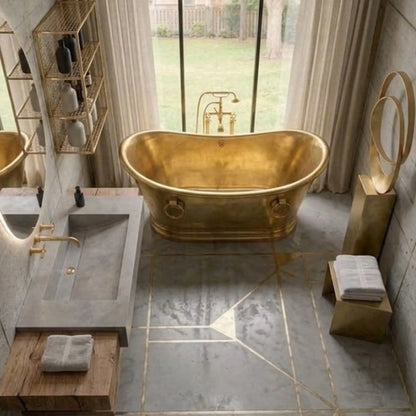 A luxury bathroom scene featuring a freestanding oval gold bathtub, a modern gray stone sink with matching gold fixtures, geometric gold tile lines on a gray floor, and a large window looking out onto a garden.