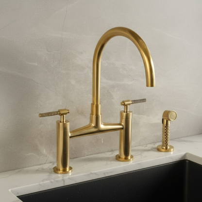 Solid unlacquered brass bridge kitchen faucet installed on sink with vintage patina finish