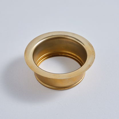 Top-down angled view of a gold-toned unlacquered brass sink flange by BrassOna.