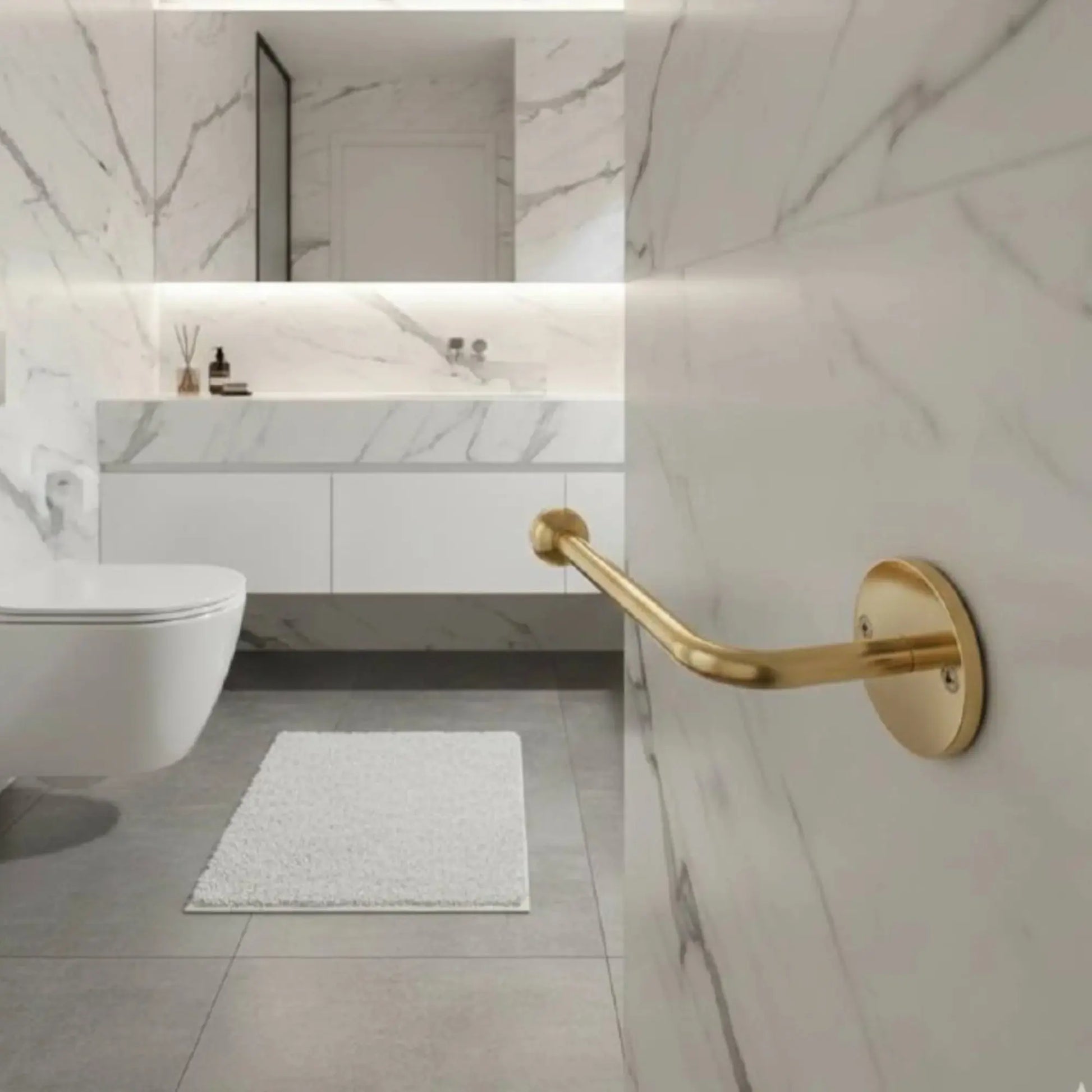 Close-up of wall-mounted unlacquered brass toilet paper holder in modern marble bathroom, solid brass accessory with natural patina aging