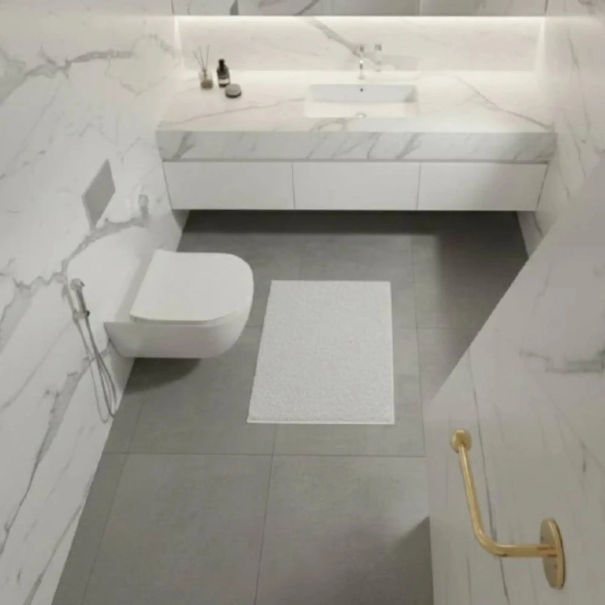 Solid unlacquered brass toilet paper holder wall mounted in luxury marble bathroom, premium brass bathroom accessory developing natural patina