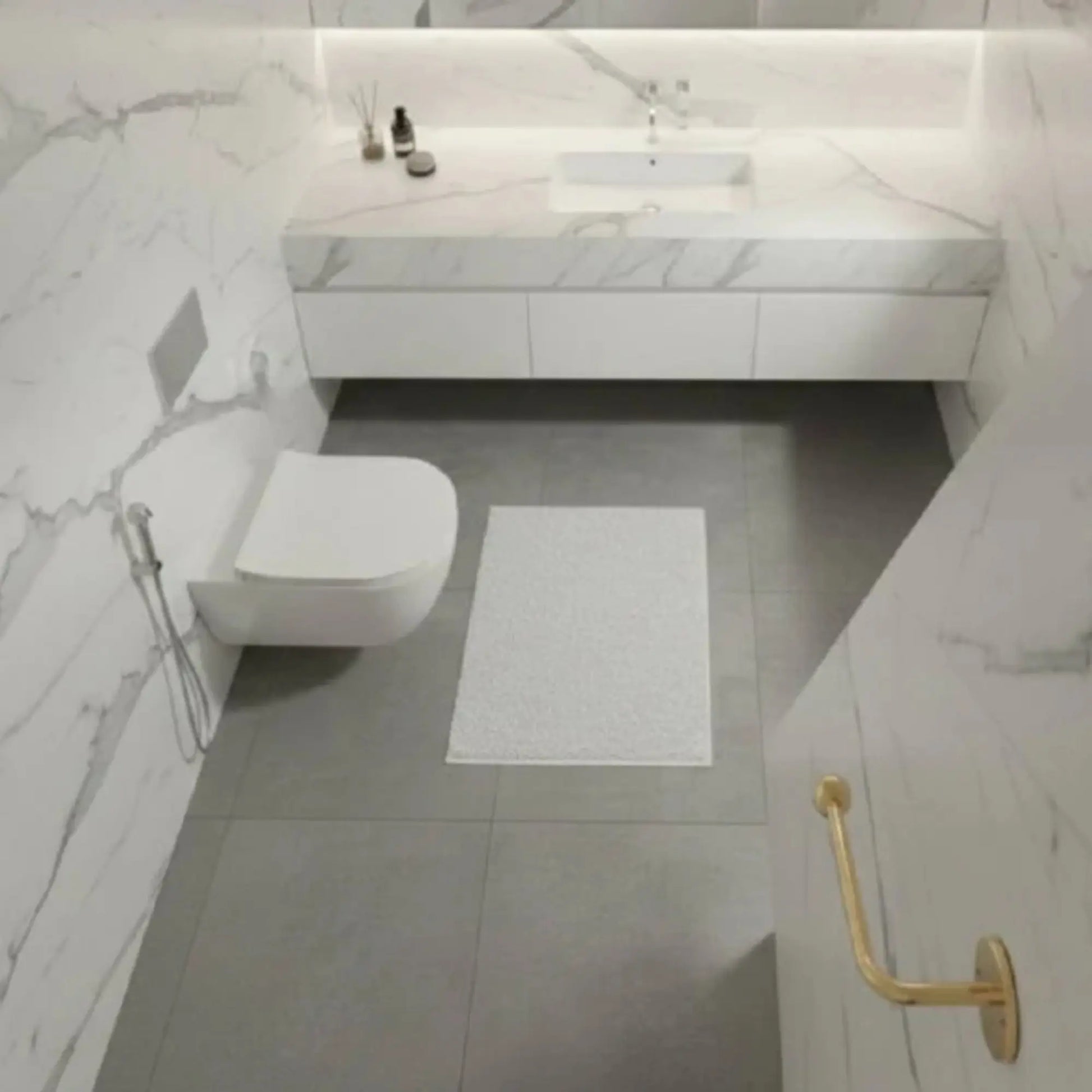 Solid unlacquered brass toilet paper holder wall mounted in luxury marble bathroom, premium brass bathroom accessory developing natural patina