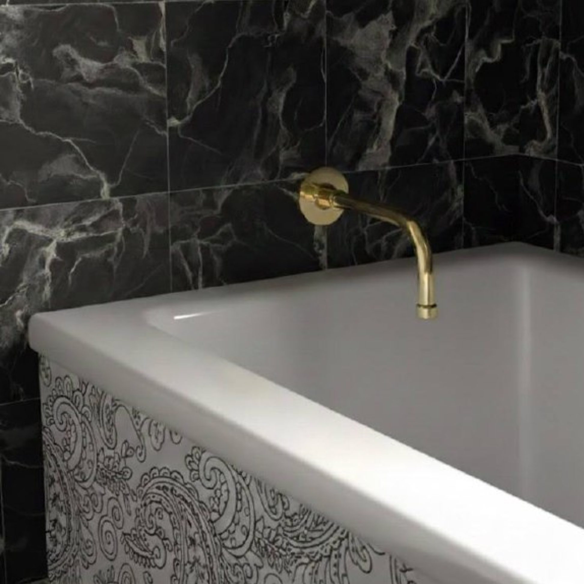 Wall-mounted unlacquered brass tub spout installed over a rectangular bathtub with black marble tile wall