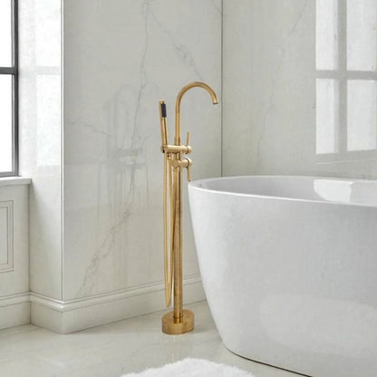 Gold freestanding bathtub faucet in a modern bathroom with marble walls.