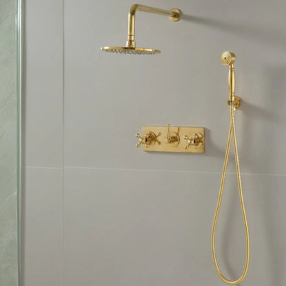 Main view of a vintage unlacquered brass wall-mounted shower system with a round rainfall head, handheld sprayer, and matching triple cross-handle controls