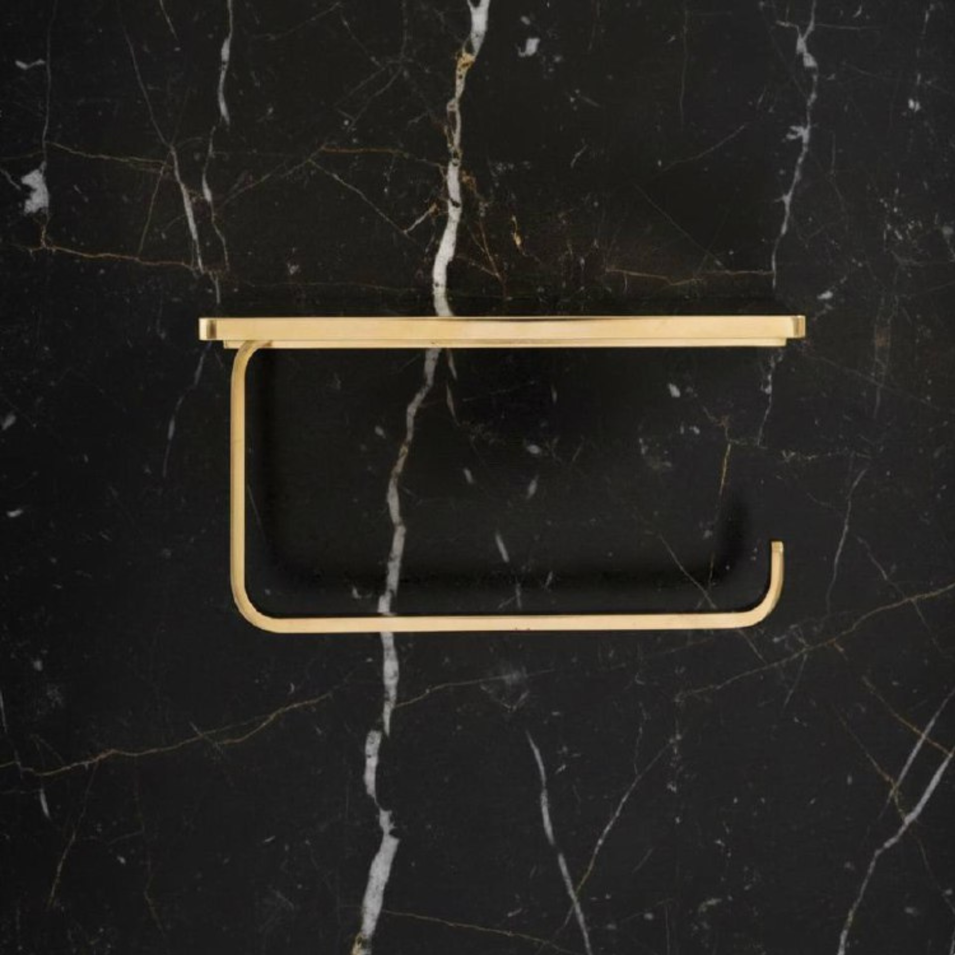 Front view of an unlacquered brass toilet paper holder with shelf, showing solid brass construction and vintage design