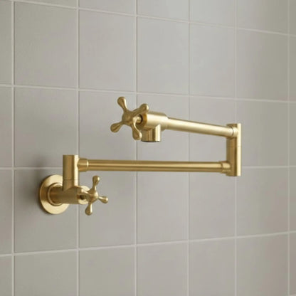 Gold kitchen faucet mounted on a tiled wall