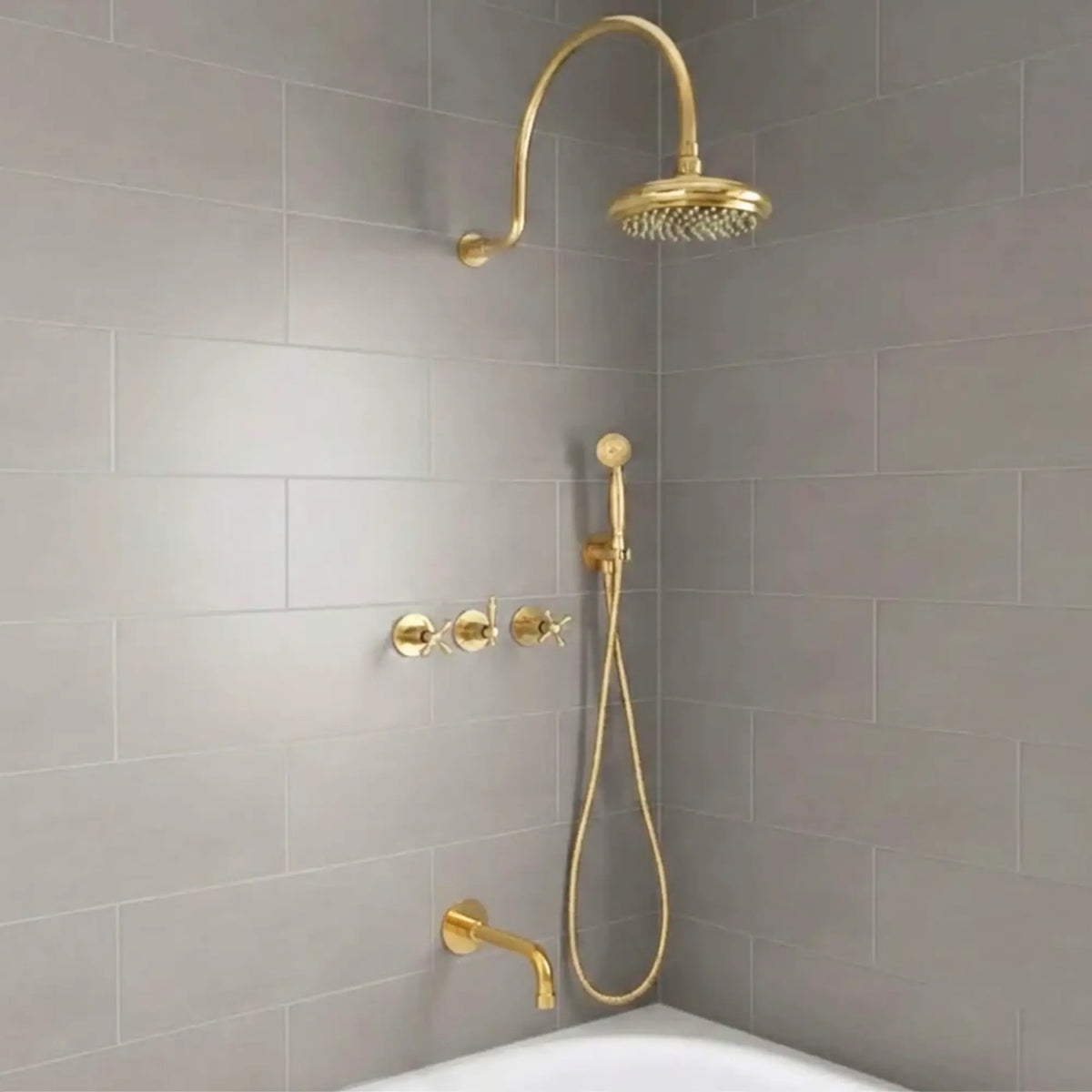 unlacquered brass rainfall shower system with handheld sprayer installed on modern bathroom gray tile wall
