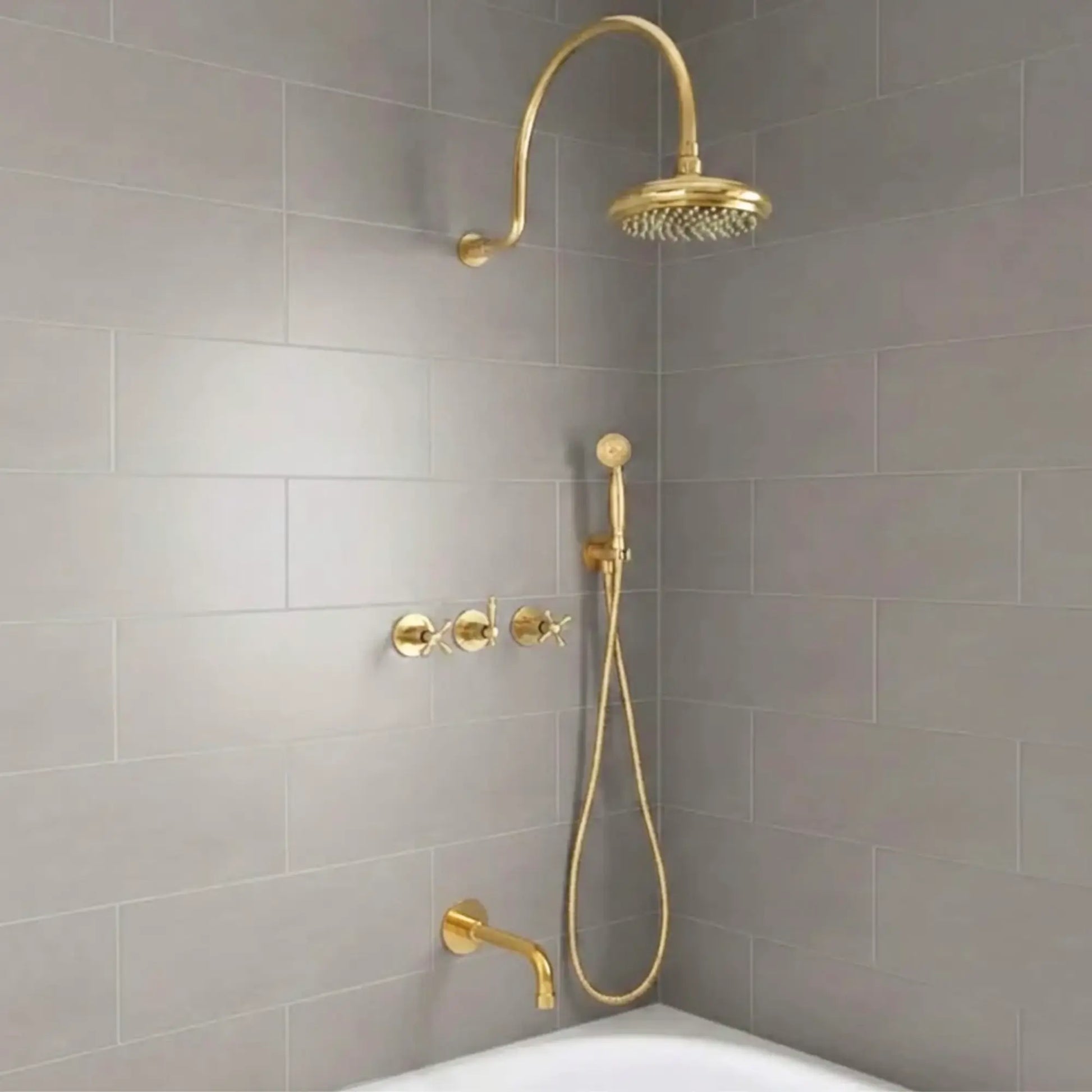 unlacquered brass rainfall shower system with handheld sprayer installed on modern bathroom gray tile wall