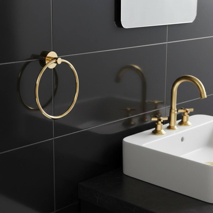 Solid unlacquered brass towel ring installed near bathroom sink with matching brass fixtures