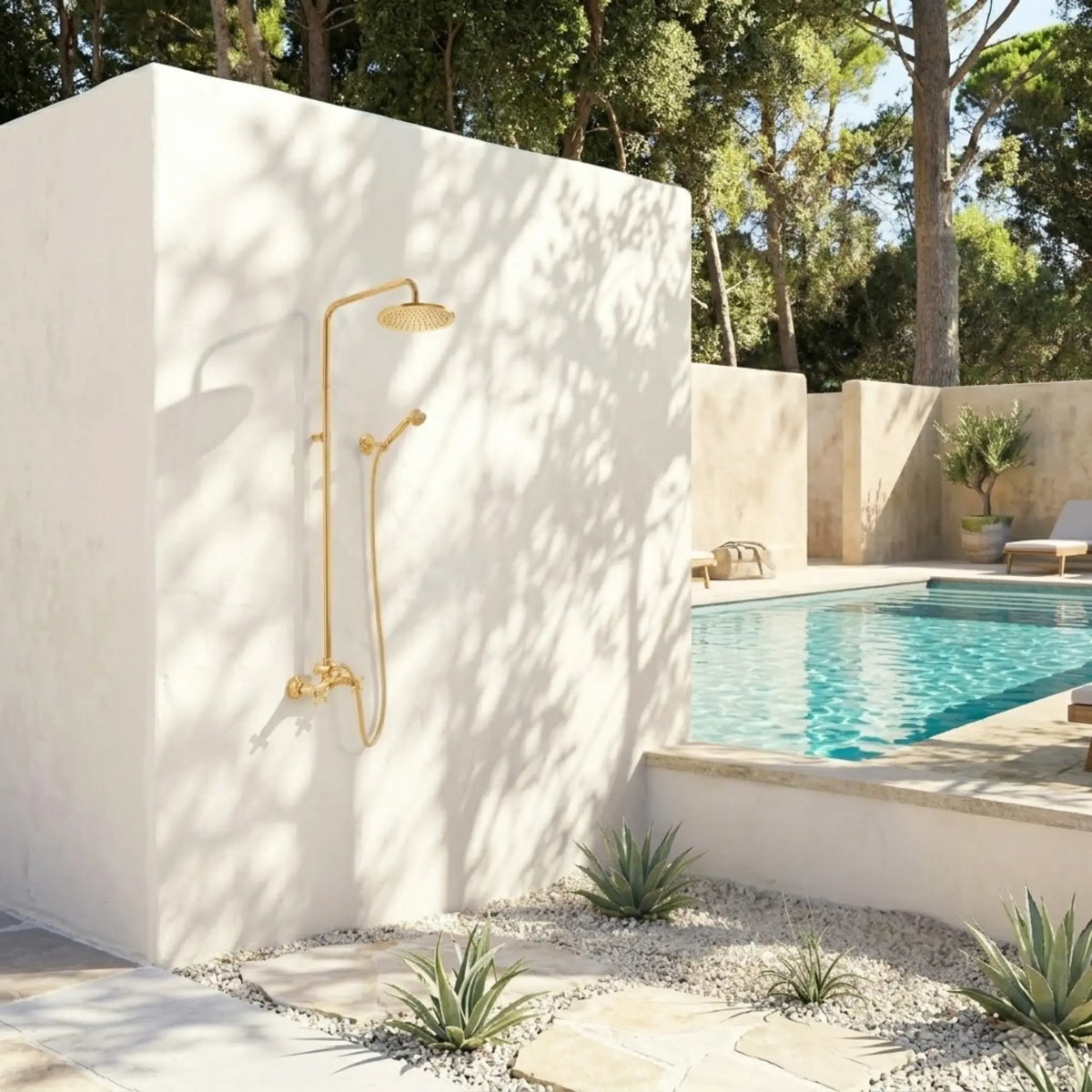 BrassOna® unlacquered brass outdoor rainfall shower system installed on white garden wall beside Mediterranean poolside landscape