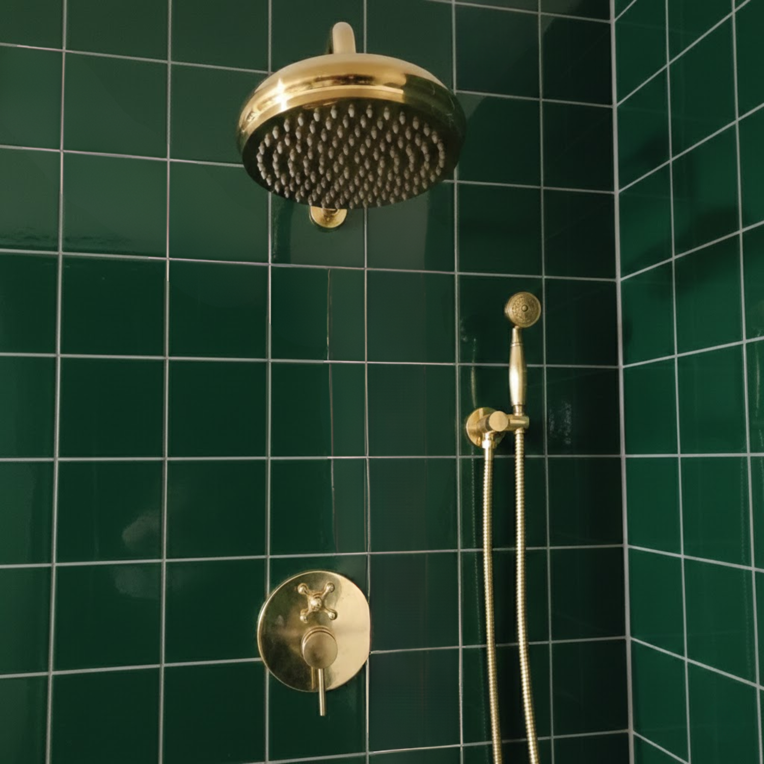 BrassOna Solid brass rain shower system with handheld shower installed against deep green tiled wall.