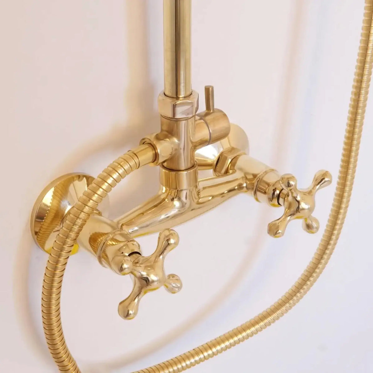 BrassOna® unlacquered brass cross handle shower valve with flexible handheld sprayer hose — close-up detail of solid brass fittings and craftsmanship