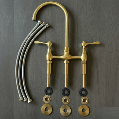 Overhead view of the disassembled bridge faucet kit, including the spout, handles, connecting hoses, and mounting hardware