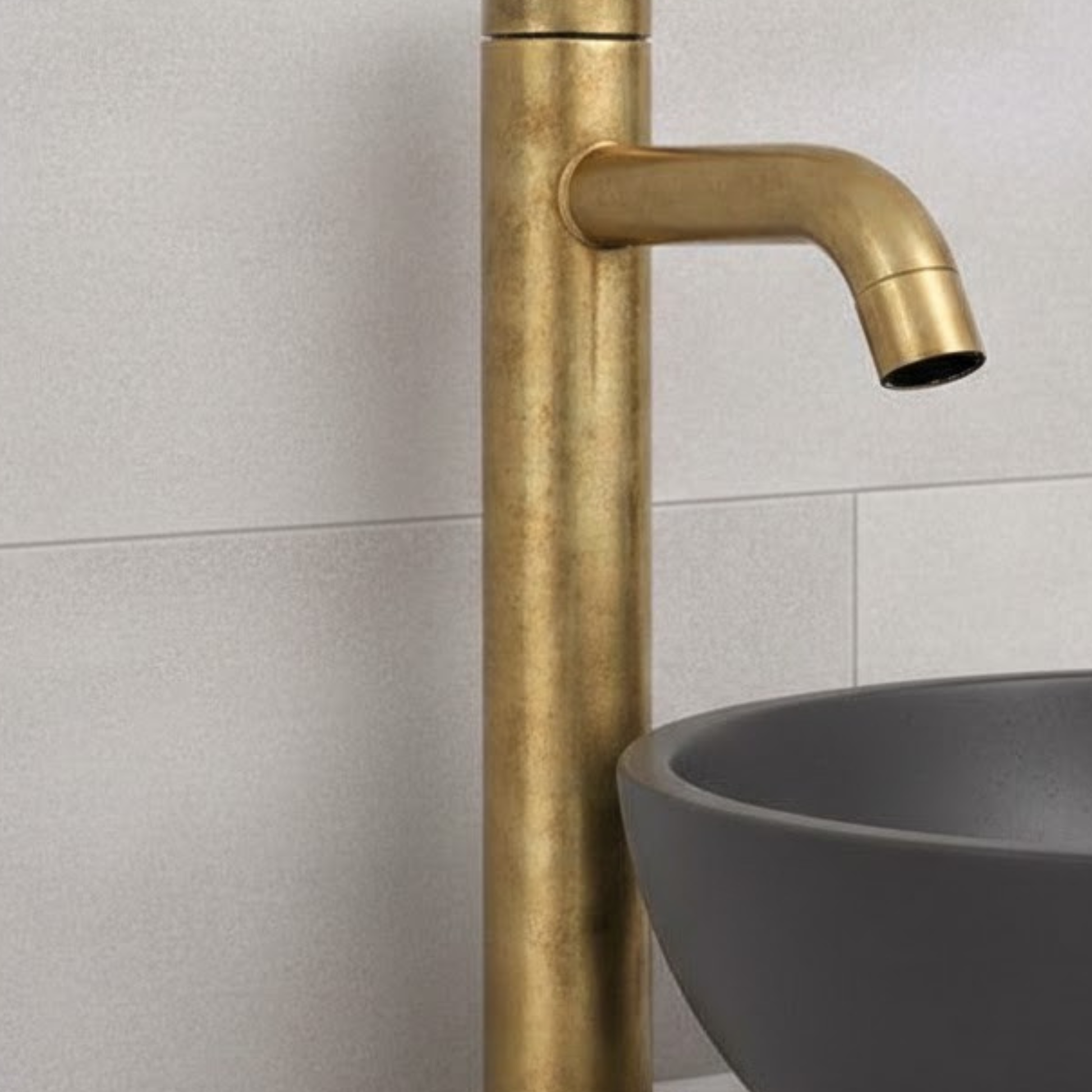 Close-up of Castello unlacquered solid brass vessel sink faucet showing natural living brass finish and curved spout detail.