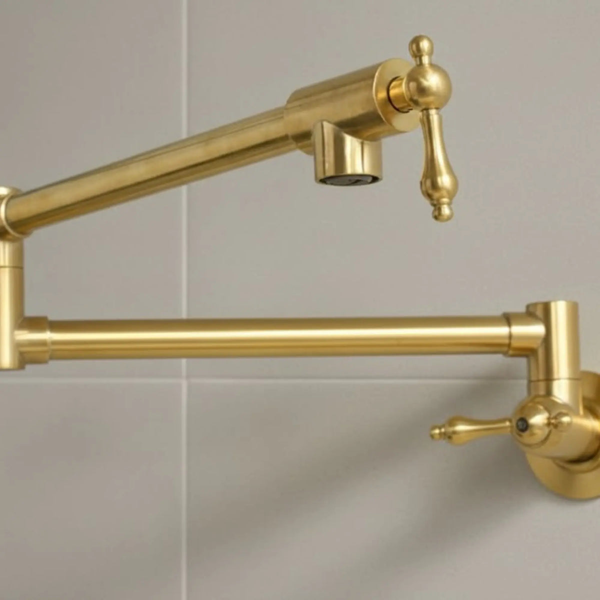Gold kitchen faucet mounted on a tiled wall