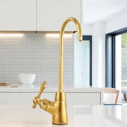 Solid brass cold water tap in a modern bright kitchen setting.
