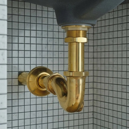 Unlacquered brass bathroom sink P-trap drain pipe kit in solid brass installed under ceramic basin with tiled wall background