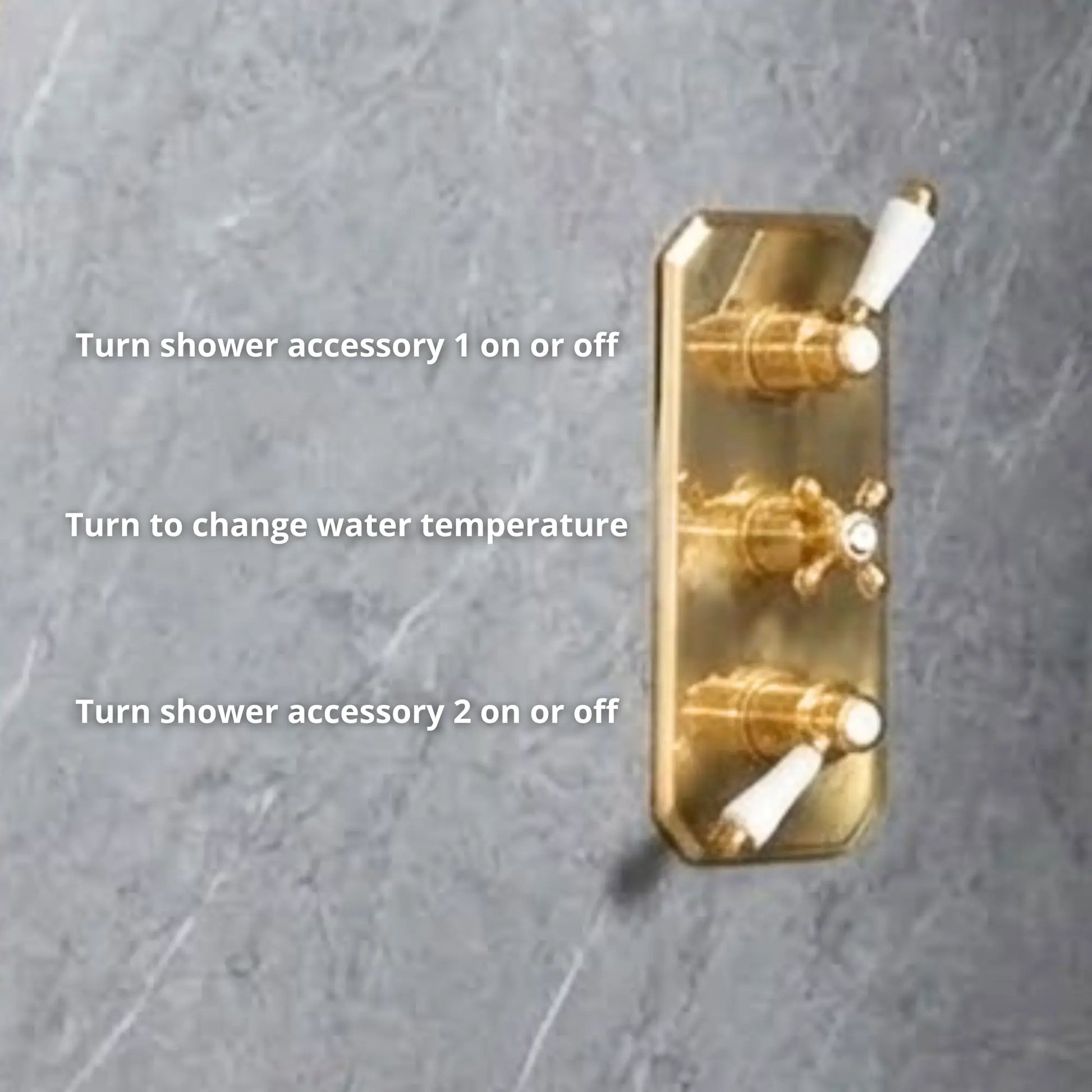 Close-up of unlacquered brass concealed thermostatic valve trim plate with three porcelain lever controls — accessory 1, temperature, and accessory 2