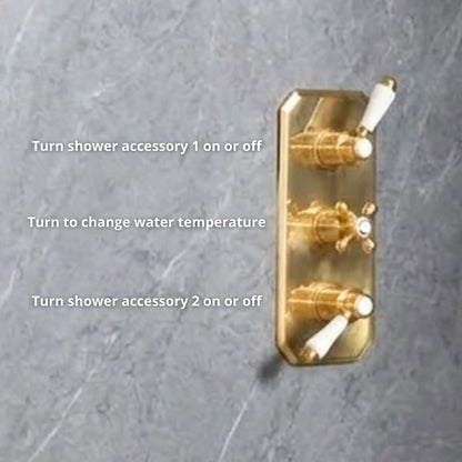 Close-up of unlacquered brass concealed thermostatic valve trim plate with three porcelain lever controls — accessory 1, temperature, and accessory 2