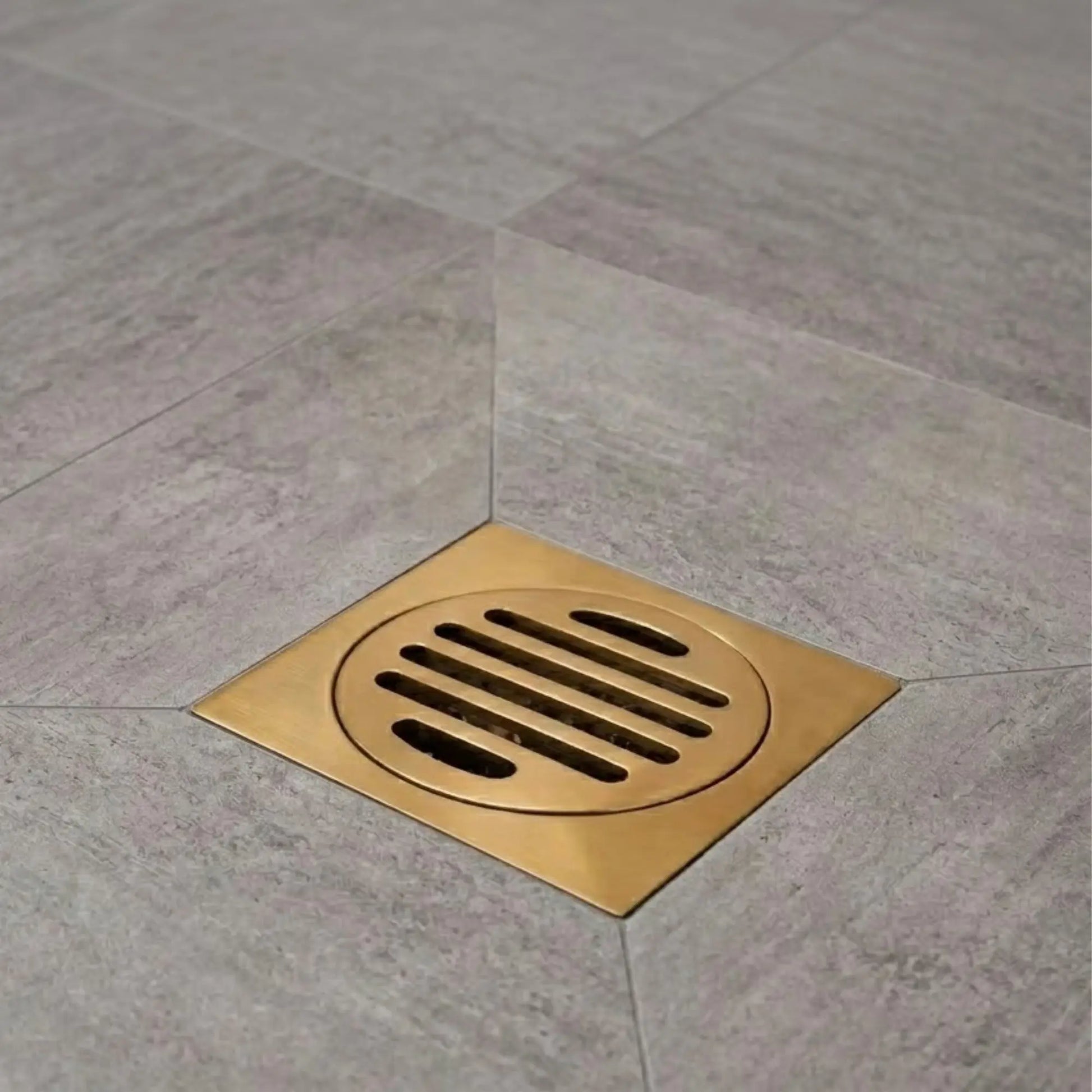 Unlacquered brass floor drain installed in shower tile floor