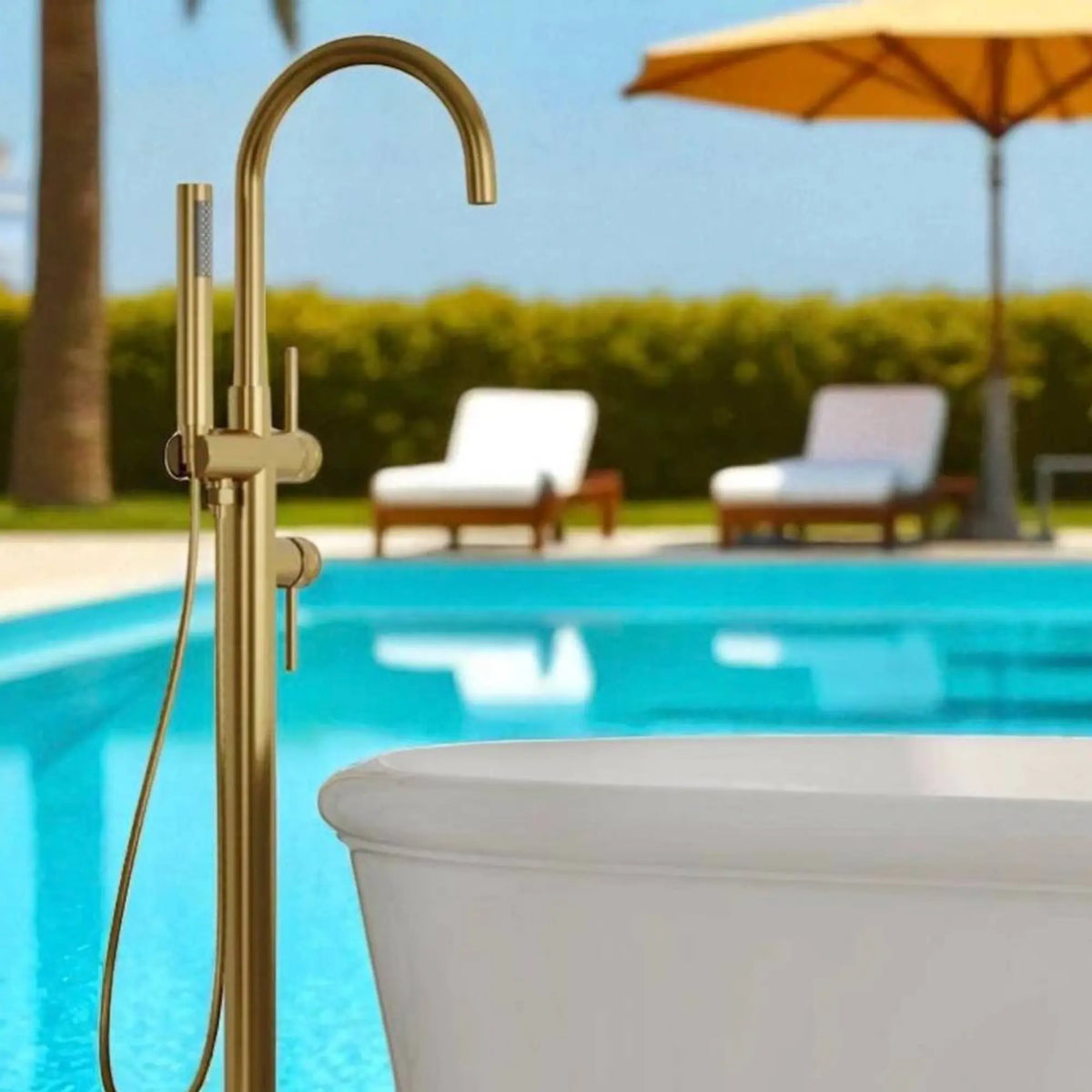 Gold outdoor shower head and hose with a pool and lounge chairs in the background