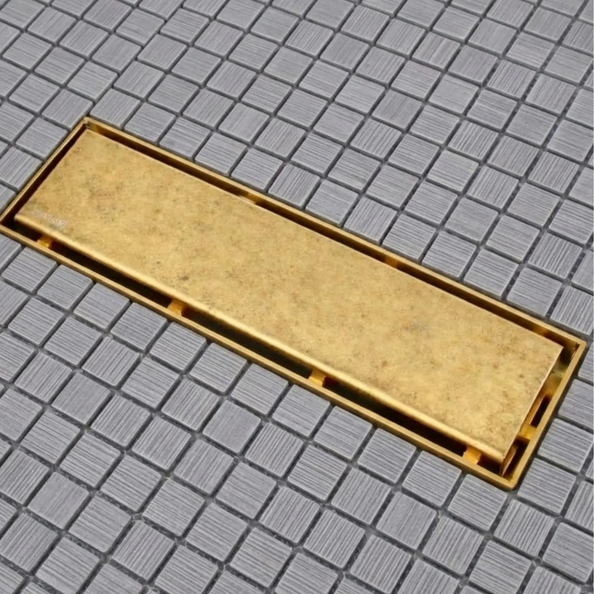Unlacquered brass linear shower drain installed flush on gray mosaic tile shower floor – BrassOna