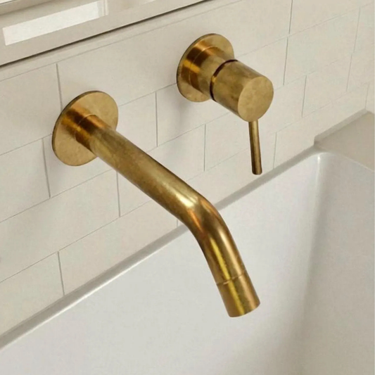 Unlacquered brass wall-mount bathroom faucet with single handle and extended spout