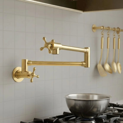 Gold kitchen faucet and utensils on a tiled wall